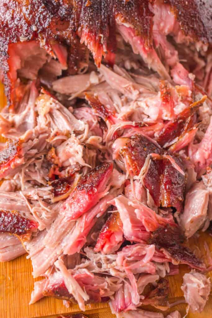 Close-up of freshly shredded grilled pulled pork showing tender meat and crispy bark.