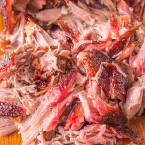 Square crop of juicy shredded pulled pork with visible bark and smoke ring.