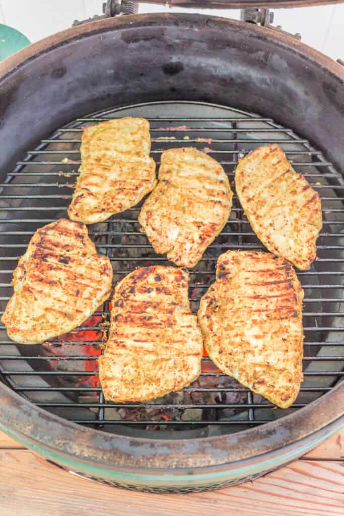Chicken breasts cooking on the grill with visible char lines