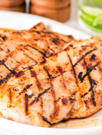 Square close-up of juicy grilled Margarita chicken breasts with lime drink