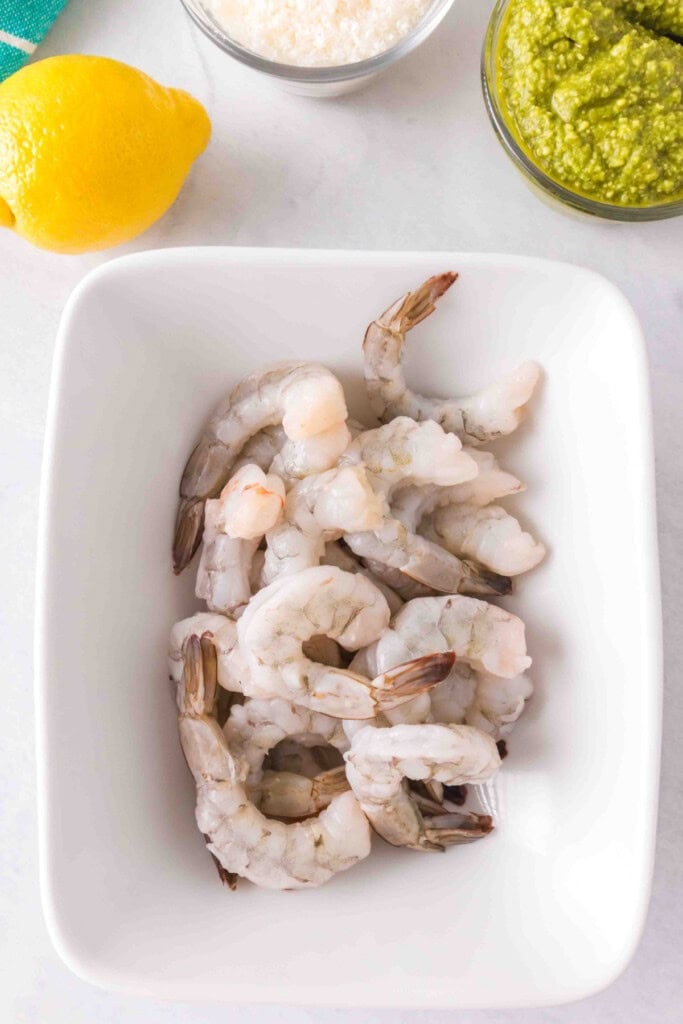 Raw jumbo shrimp in a white bowl, ready to be marinated