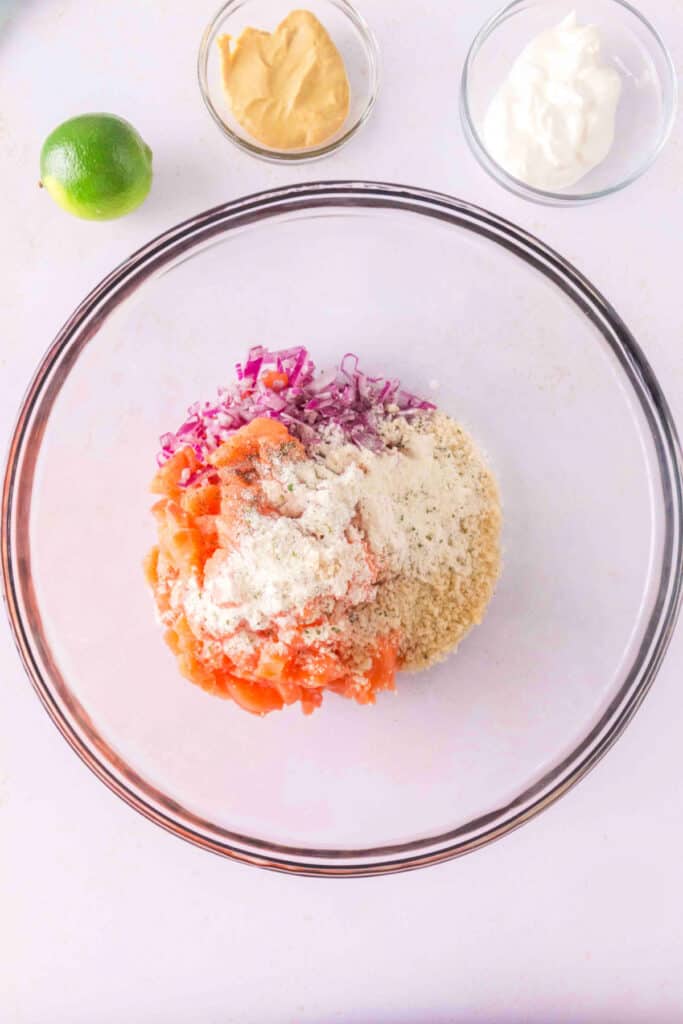Mixing bowl with chopped salmon, red onion, panko, and ranch seasoning before combining