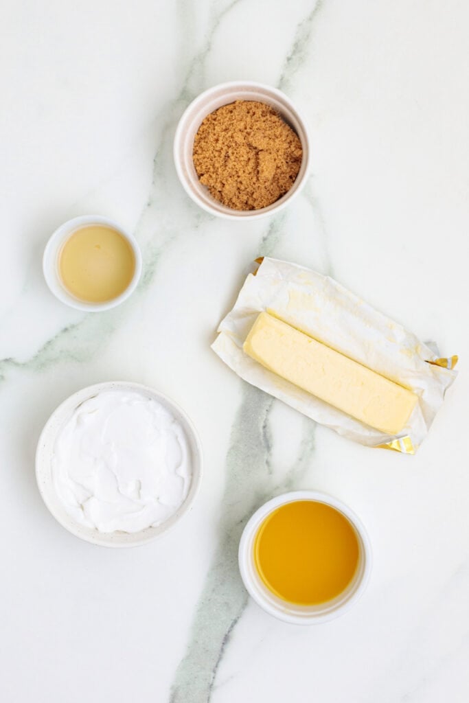 Overhead view of coconut rum butter sauce ingredients including butter, sugar, and coconut milk