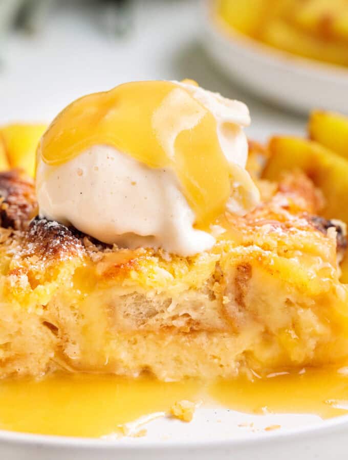 Square-cropped image of Piña Colada Bread Pudding with vanilla ice cream and golden sauce