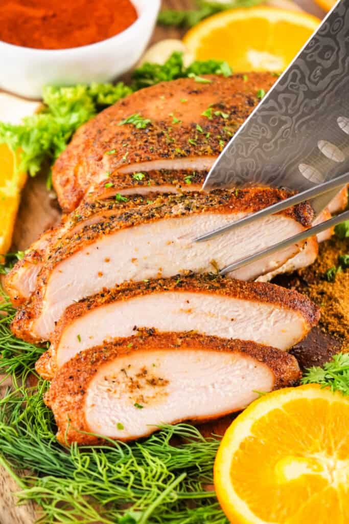 Juicy Cajun turkey breast being sliced with a knife and carving fork