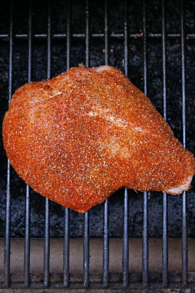 Seasoned Cajun turkey breast cooking directly on the smoker grates