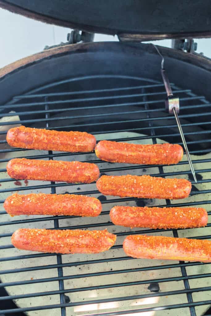 Seasoned hot dogs placed on a smoker grill rack, ready to cook at 250°F