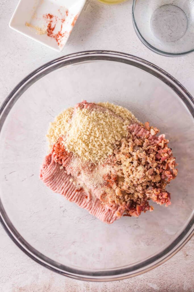 Ground turkey mixture in a bowl topped with panko breadcrumbs and seasonings.