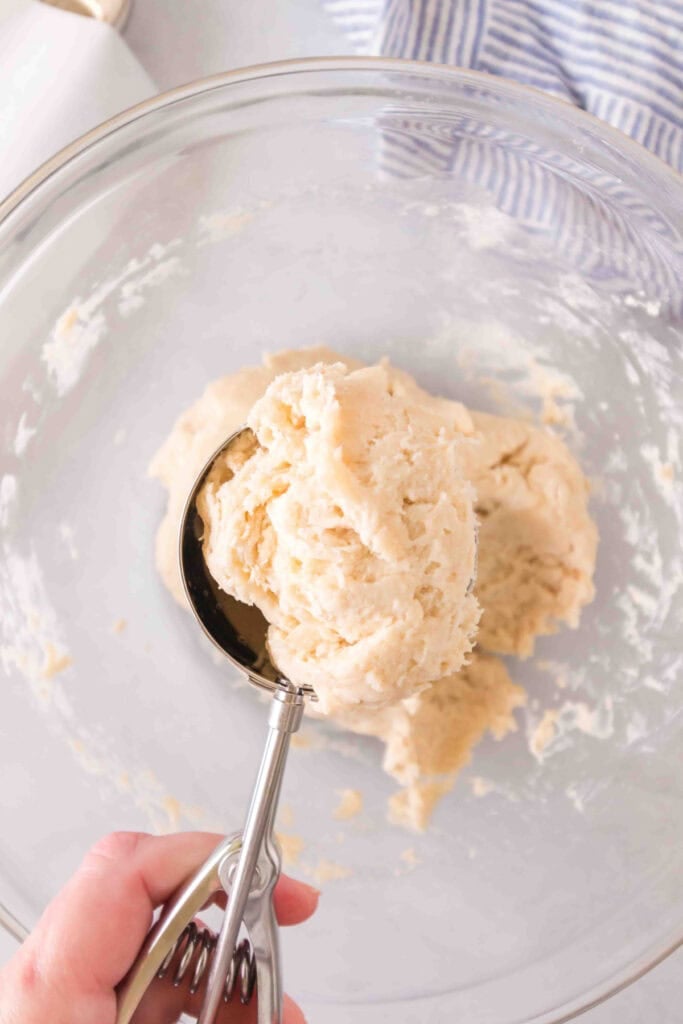 Close-up of thick dough being scooped with a large cookie scoop