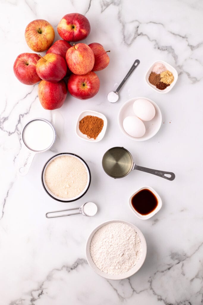 Overhead shot of fresh apples and individual measured ingredients on marble counter