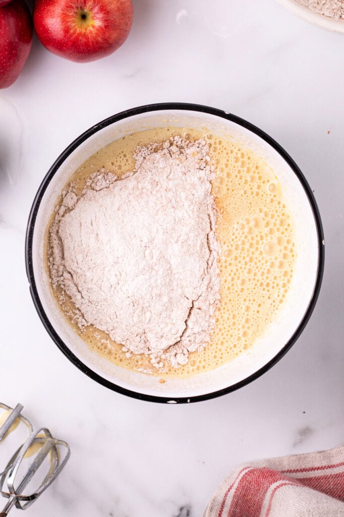 Dry ingredients being added to wet ingredients in the mixing bowl