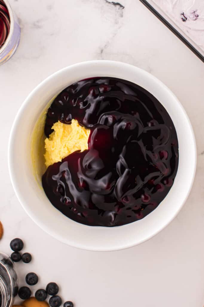 Blueberry pie filling poured over thick vanilla pudding in a mixing bowl