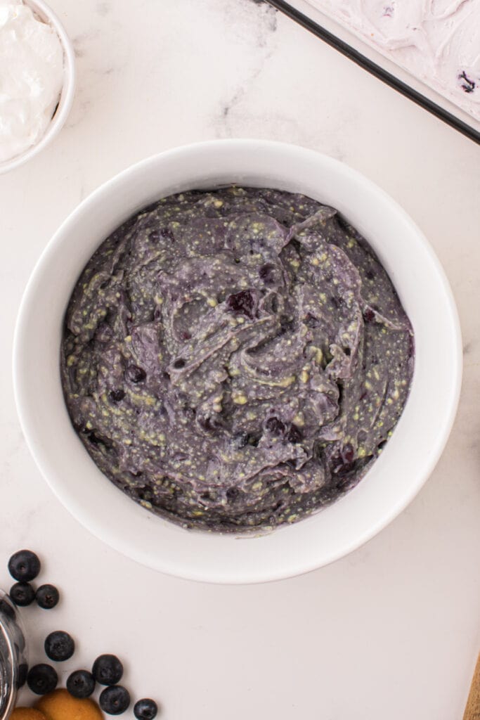 Thick blueberry pudding mixture almost fully combined