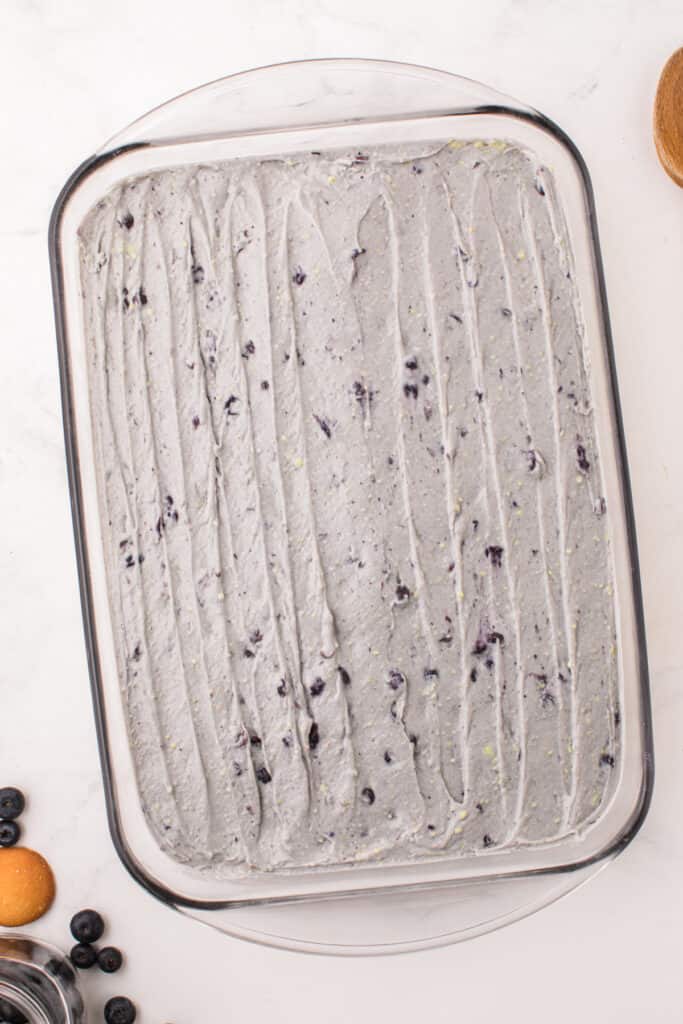 Top view of smoothed out blueberry pudding layer in the baking dish