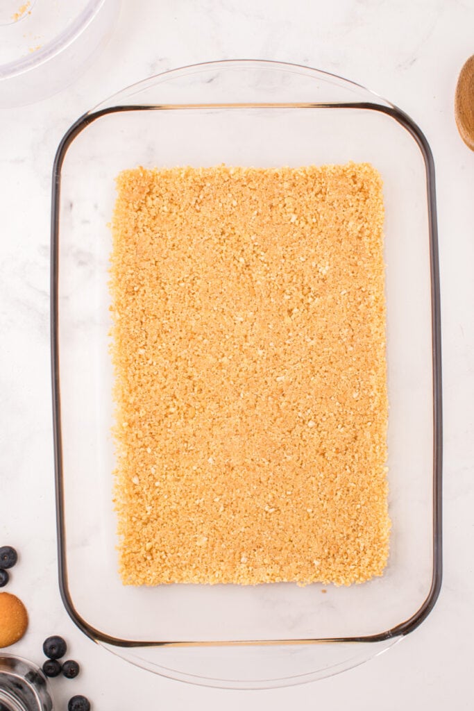 Pressed cookie crust evenly spread in a 9x13 inch glass baking dish
