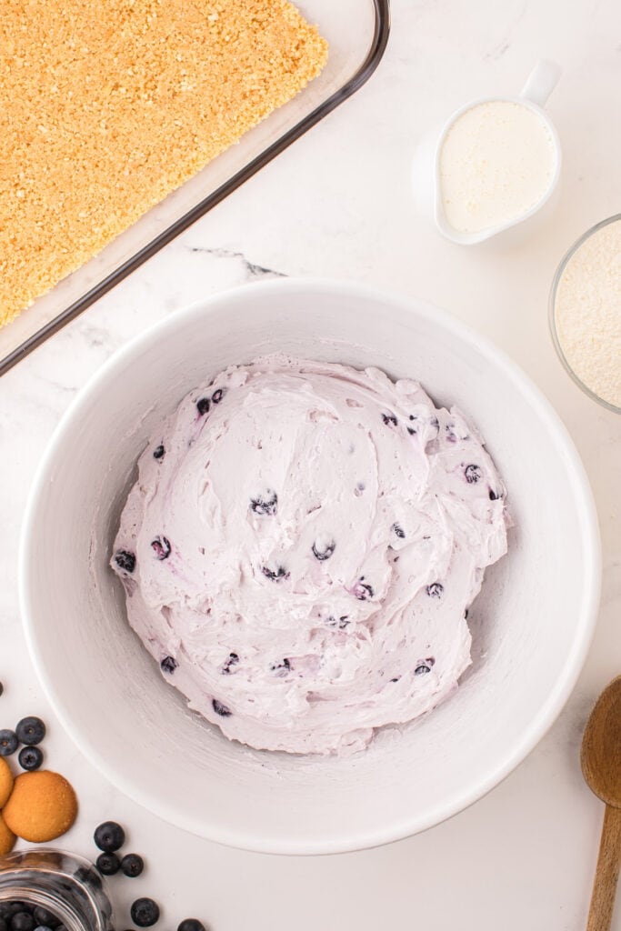 Cheesecake and blueberry mixture fully blended in a large bowl