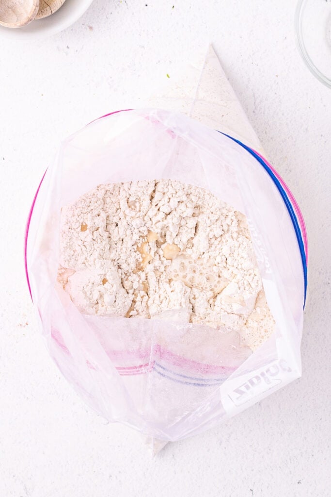 Warm water and oil added to flour mixture in a Ziploc bag