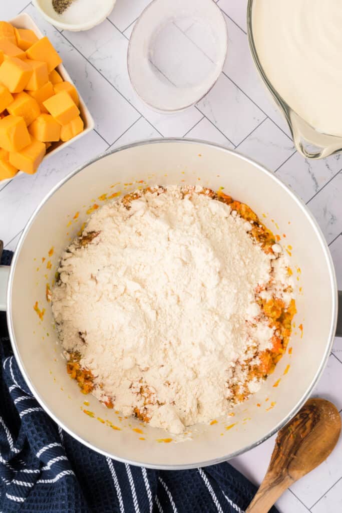A mound of flour added to the sautéed vegetables in the pot to create a roux.