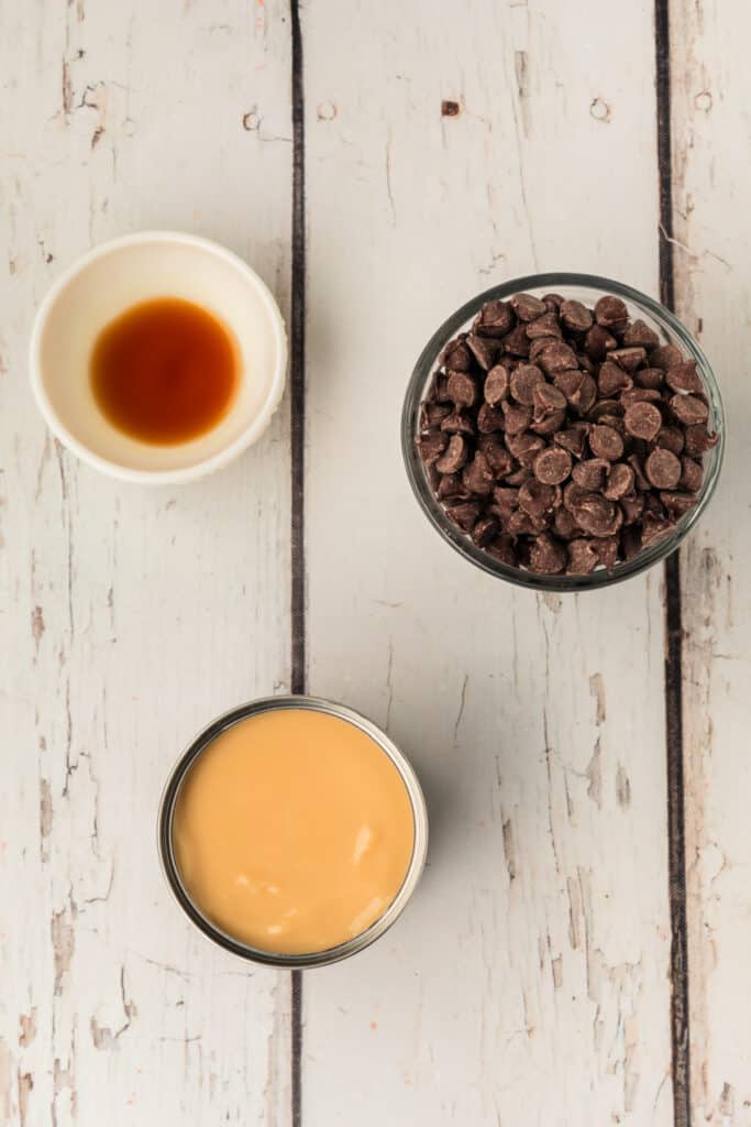 Overhead shot of ingredients for the glaze including vanilla extract, chocolate chips, and sweetened condensed milk.