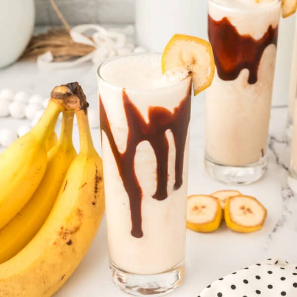 Close-up of a Dirty Banana Cocktail with chocolate syrup and banana garnish in a square format