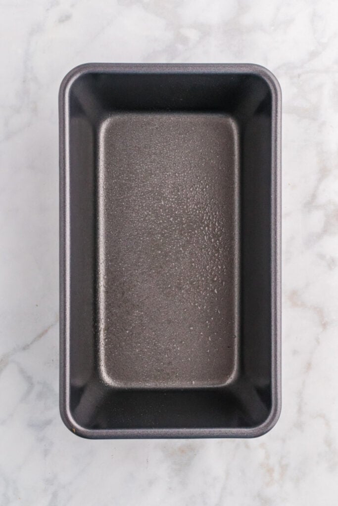Empty 9x5-inch loaf pan sprayed with nonstick cooking spray, ready for batter.