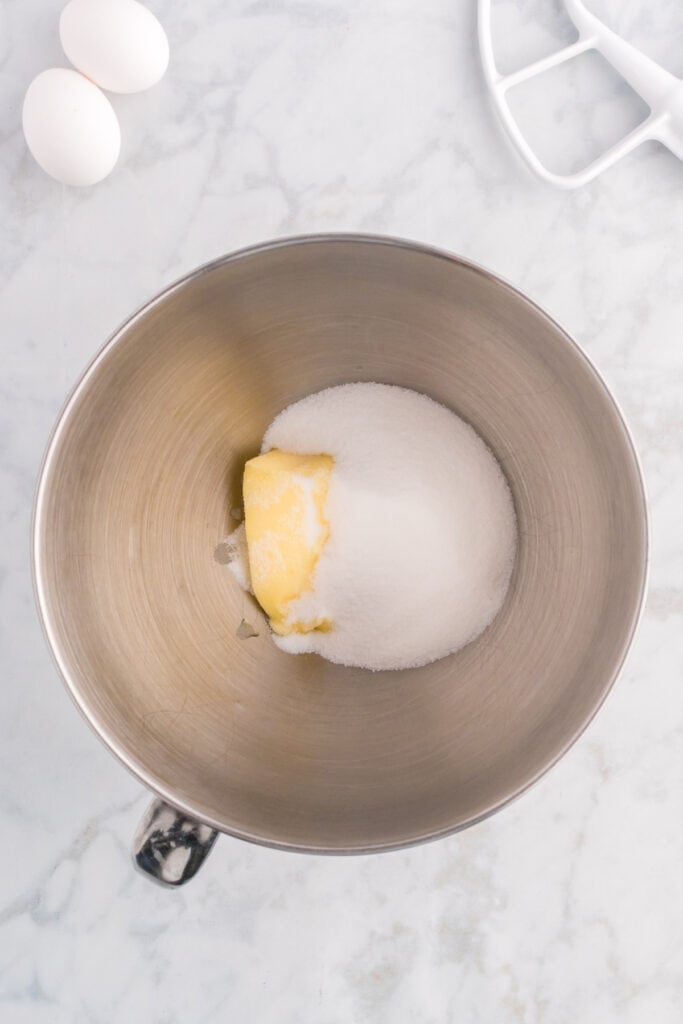 Stand mixer bowl with softened butter and granulated sugar.