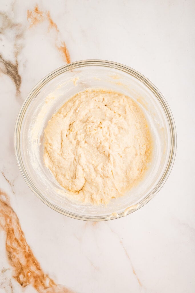 Sticky doughnut batter fully mixed in a glass bowl, ready for frying