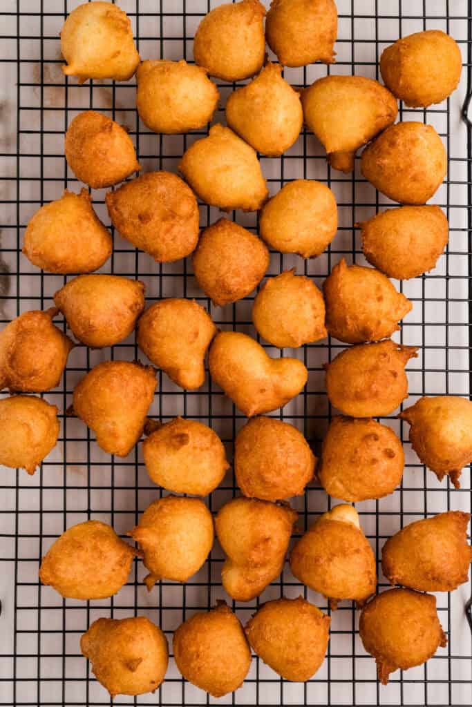 Freshly fried donut holes cooling on a wire rack