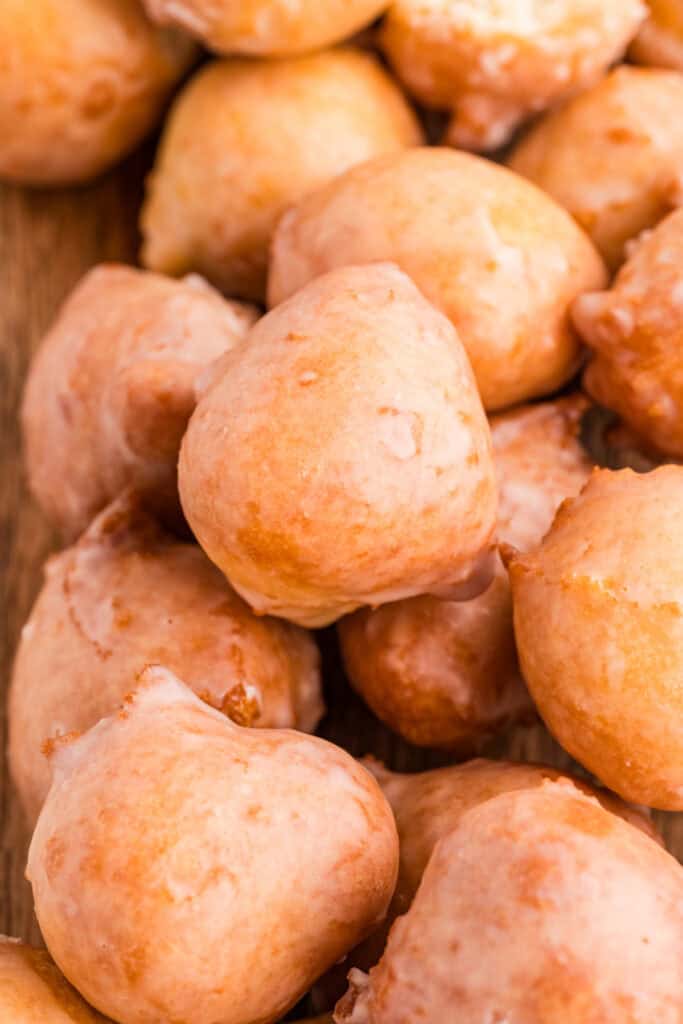 Pile of glazed donut holes on a wooden board