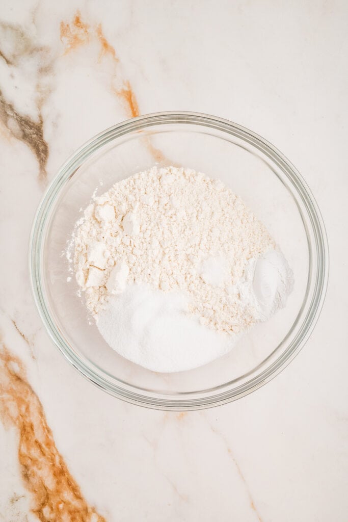 Dry ingredients including flour, sugar, and baking powder in a mixing bowl