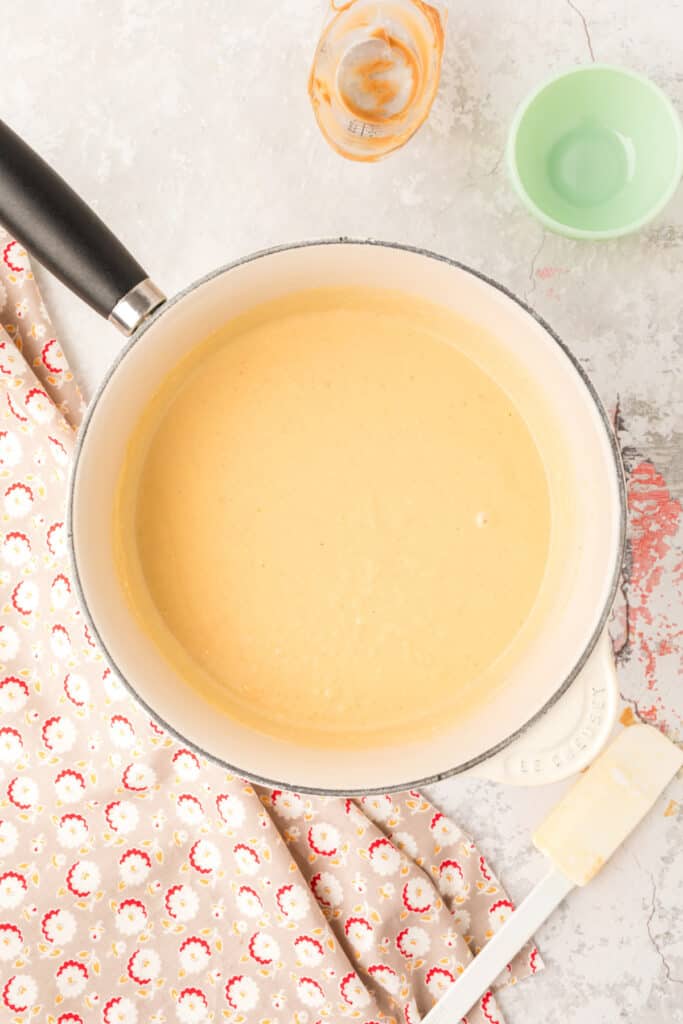 Fully mixed peanut butter custard base in the saucepan with a smooth light brown texture.