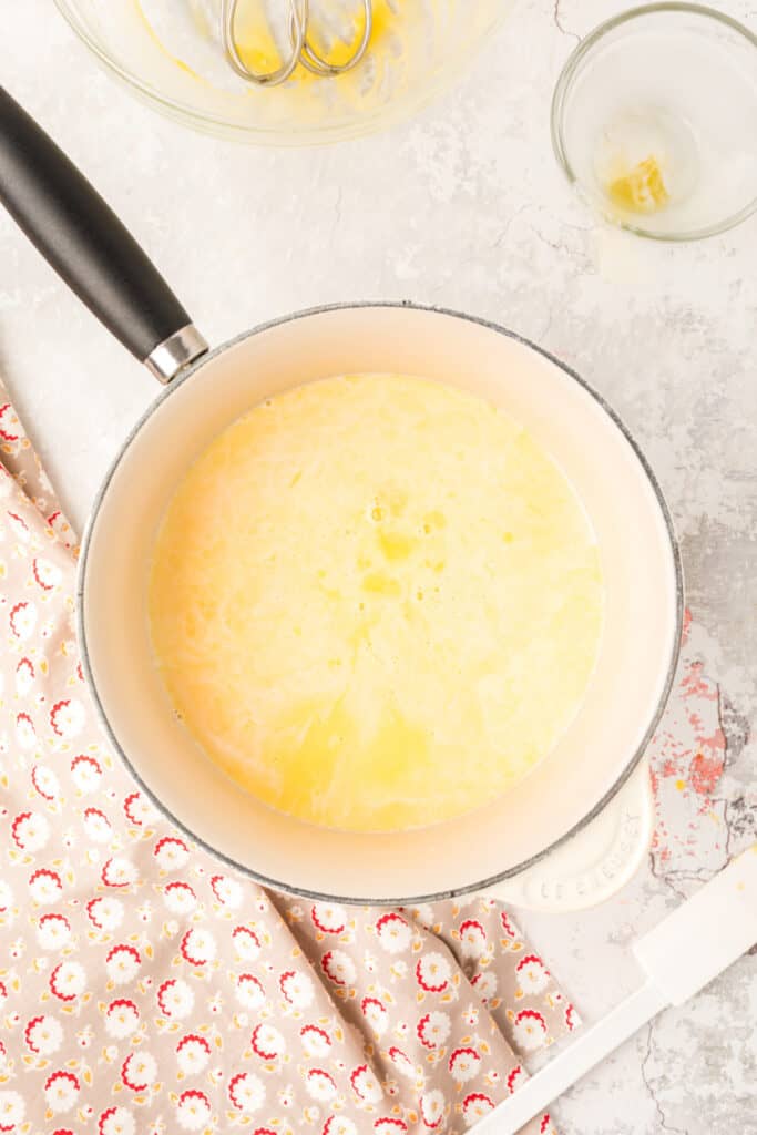 Egg and cream custard cooking on the stovetop in a Dutch oven to thicken.