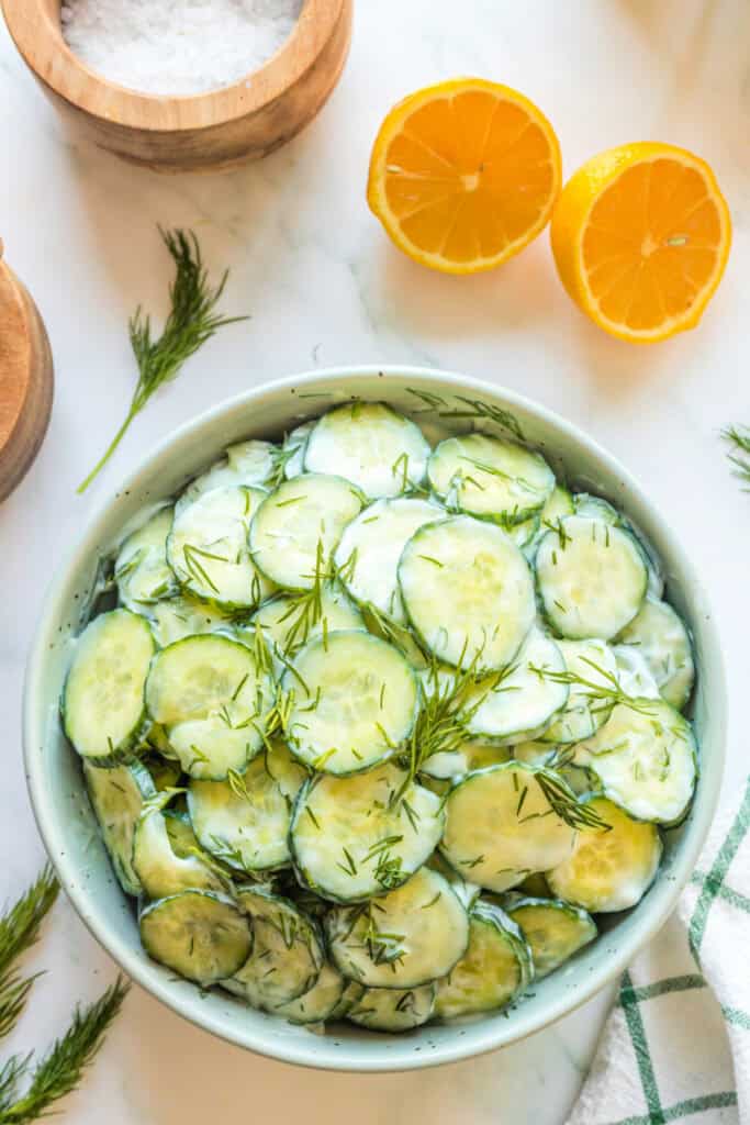 Overhead view of finished Polish cucumber salad garnished with fresh dill