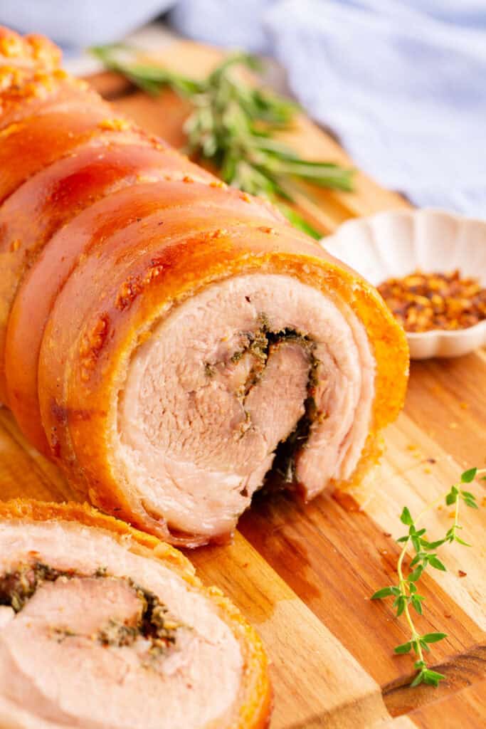 Close-up of sliced porchetta showing juicy interior and crispy rolled skin