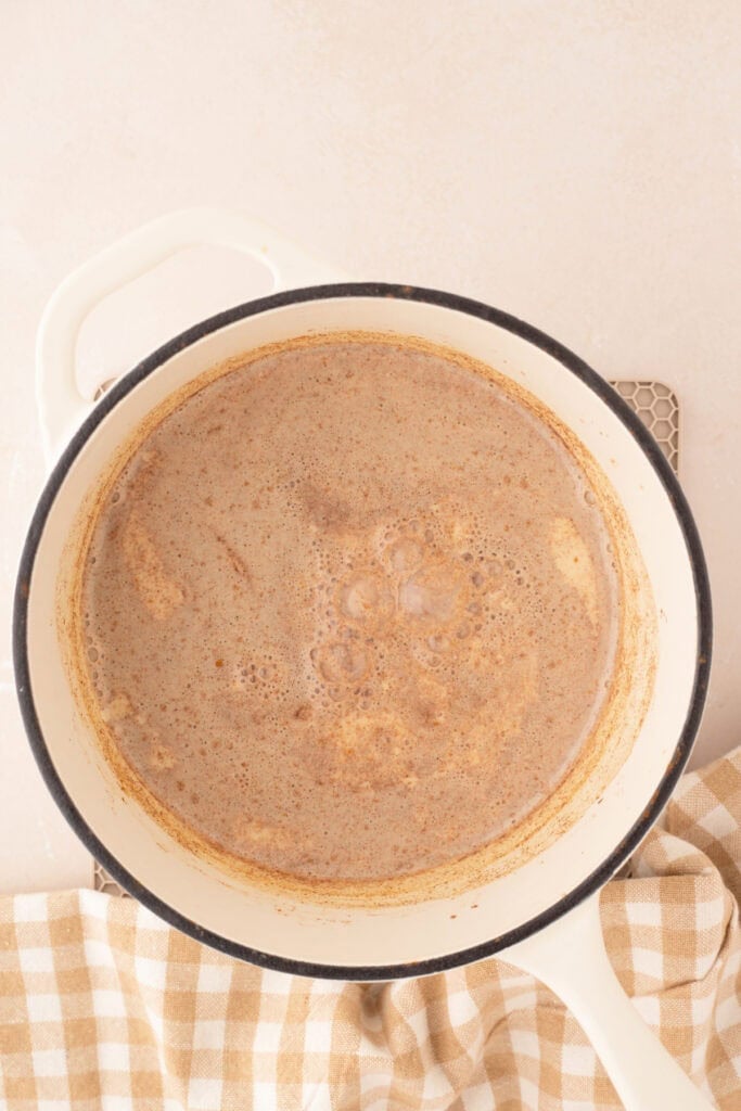 Simmering pumpkin spice creamer in a white Dutch oven