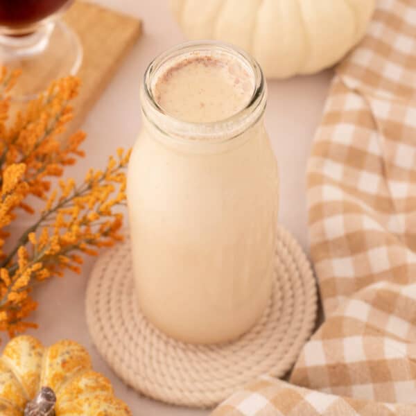 Square image of a glass bottle filled with pumpkin spice creamer