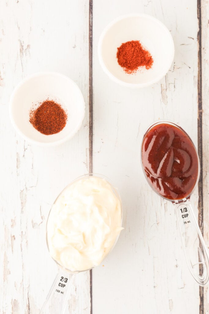 Measured ingredients for Campfire Sauce laid out on a rustic white surface