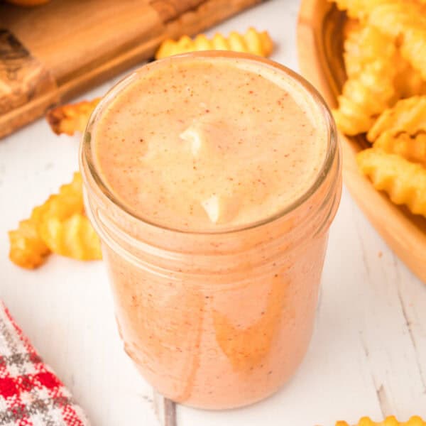 Overhead view of Campfire Sauce in a jar surrounded by waffle fries