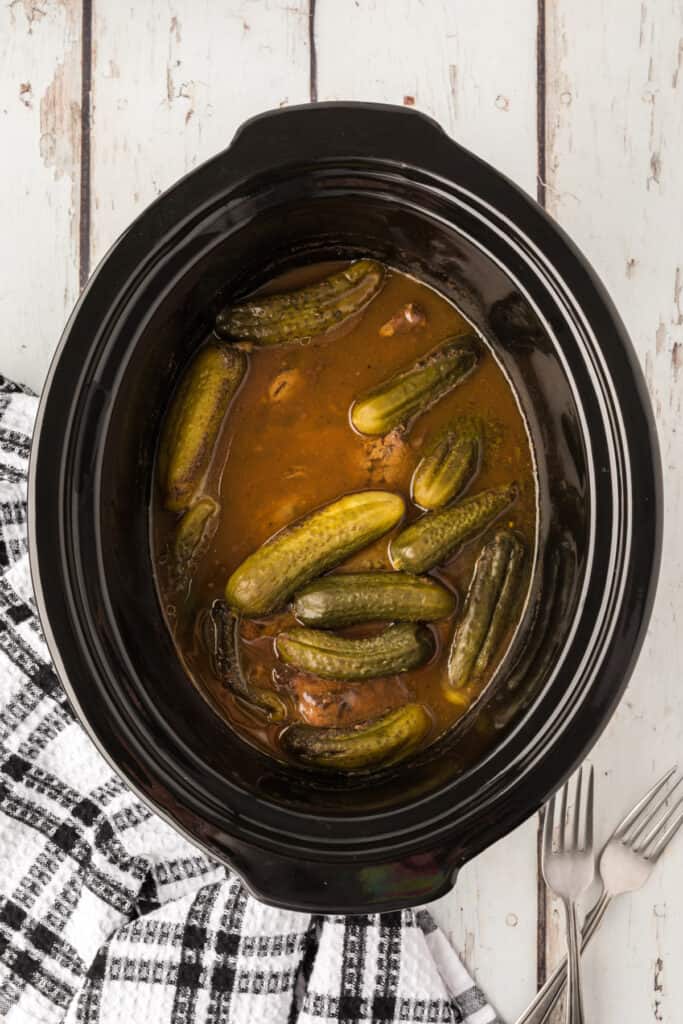 Fully cooked dill pickle roast in juices inside the slow cooker
