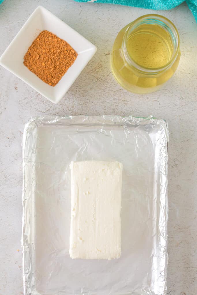 	Overhead view of cream cheese, olive oil, and BBQ seasoning on a prep tray