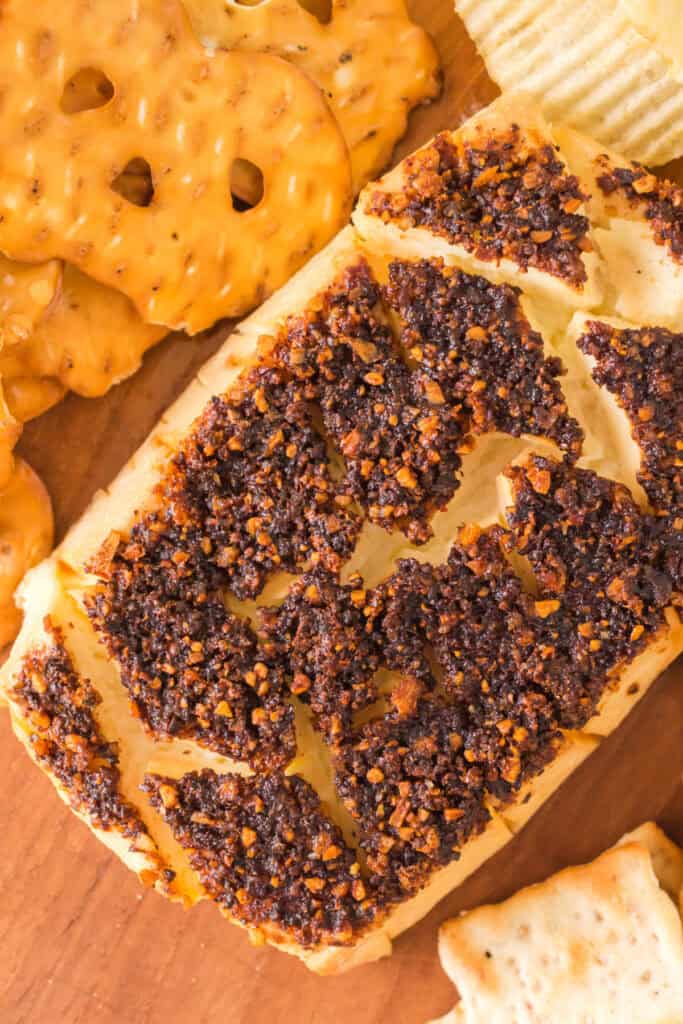 Smoked cream cheese served on a wooden board with pretzel thins and chips