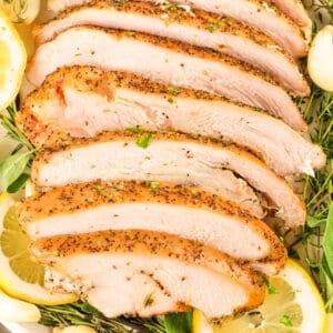 Square image of sliced smoked garlic herb turkey breast with lemon and herbs