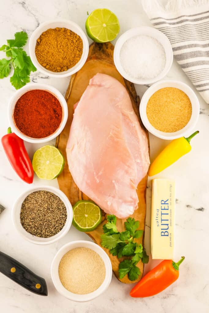 Raw turkey breast with all ingredients and seasonings laid out around it