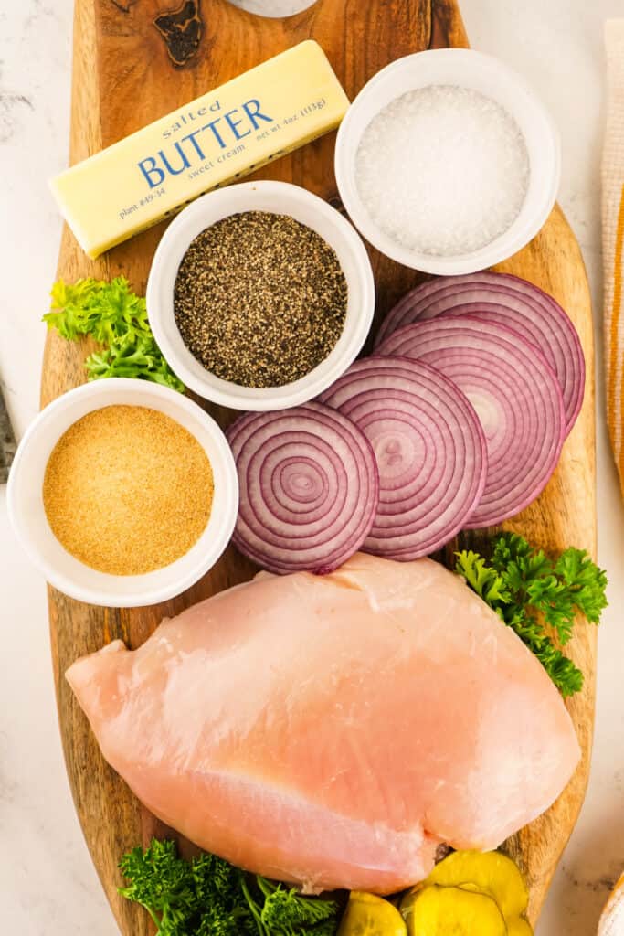 Ingredients for smoked turkey laid out, including butter, garlic, seasonings, and turkey breast