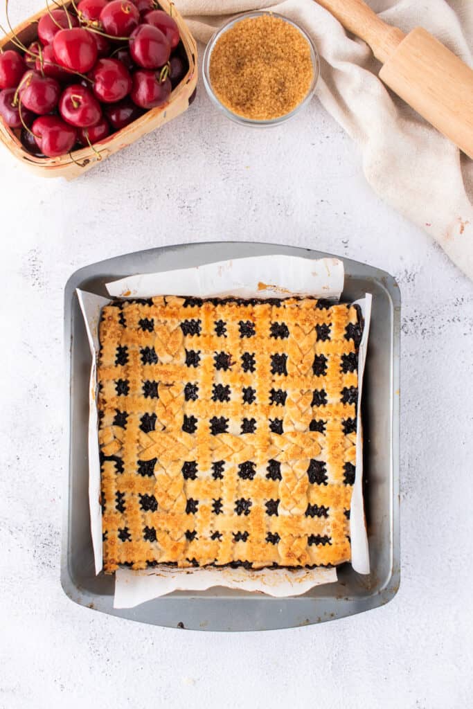 Full 8x8 pan of baked cherry pie bars with an intricate lattice crust