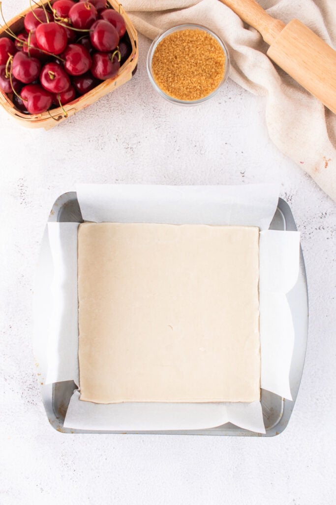 Unbaked bottom pie crust pressed into a parchment-lined 8x8 inch baking pan