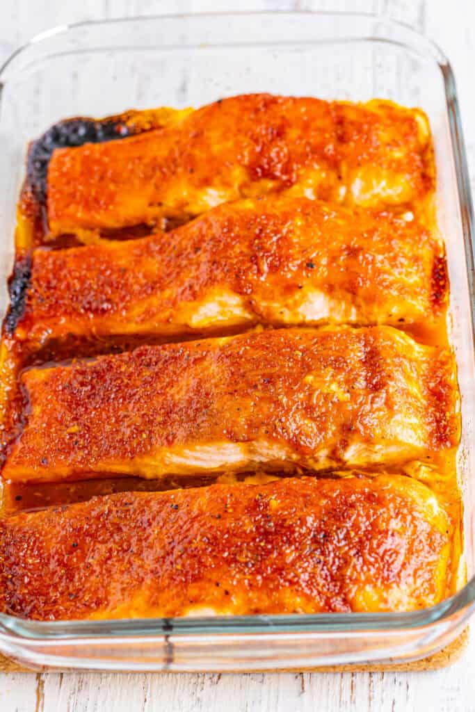 Baked firecracker salmon in a glass dish with caramelized top edges.
