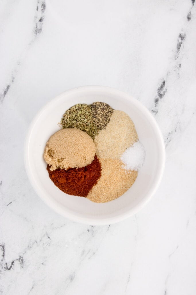 Close-up of spices for blackened salmon seasoning arranged neatly in a white bowl.