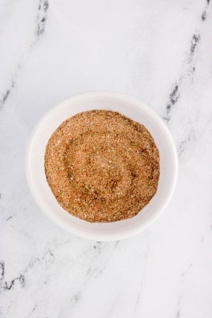 Mixed blackened salmon seasoning blend in a small white bowl.
