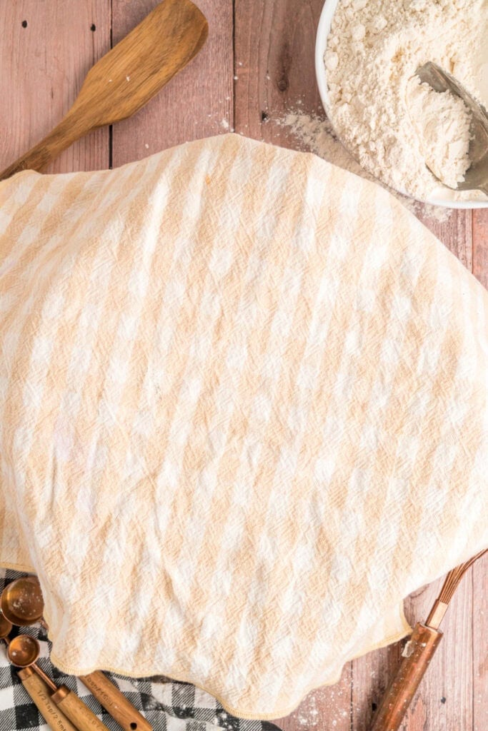 Bowl covered with a kitchen towel as dough rises during the first proof of Amish white bread.